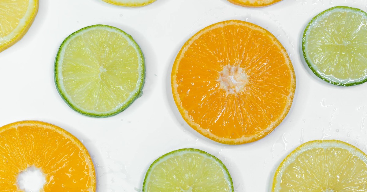 Colorful citrus slices including orange, lemon, and lime on a white background.