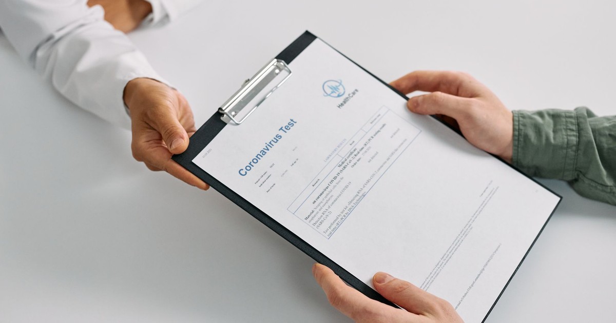 A doctor hands over coronavirus test results to a patient during a consultation in a medical clinic.