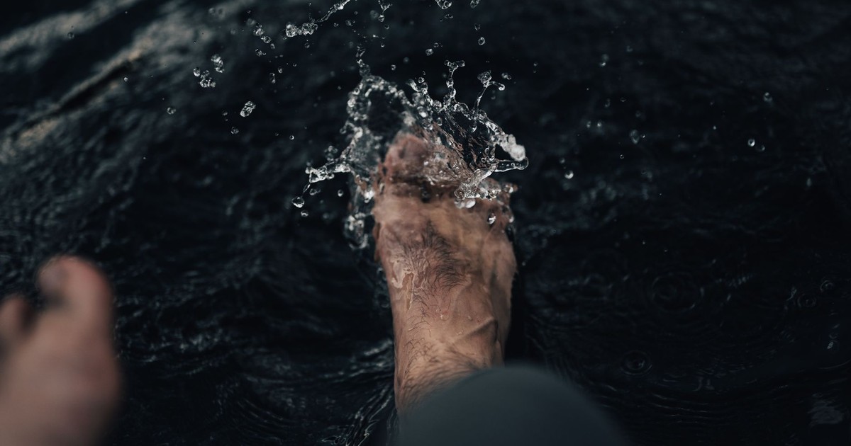 Close-up of a foot splashing and playing in water. Captures motion and refreshment.