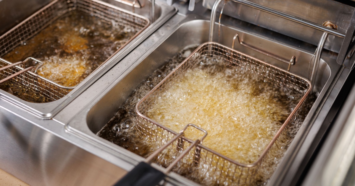 Frying potatoes in fryer for french fries in a restaurant