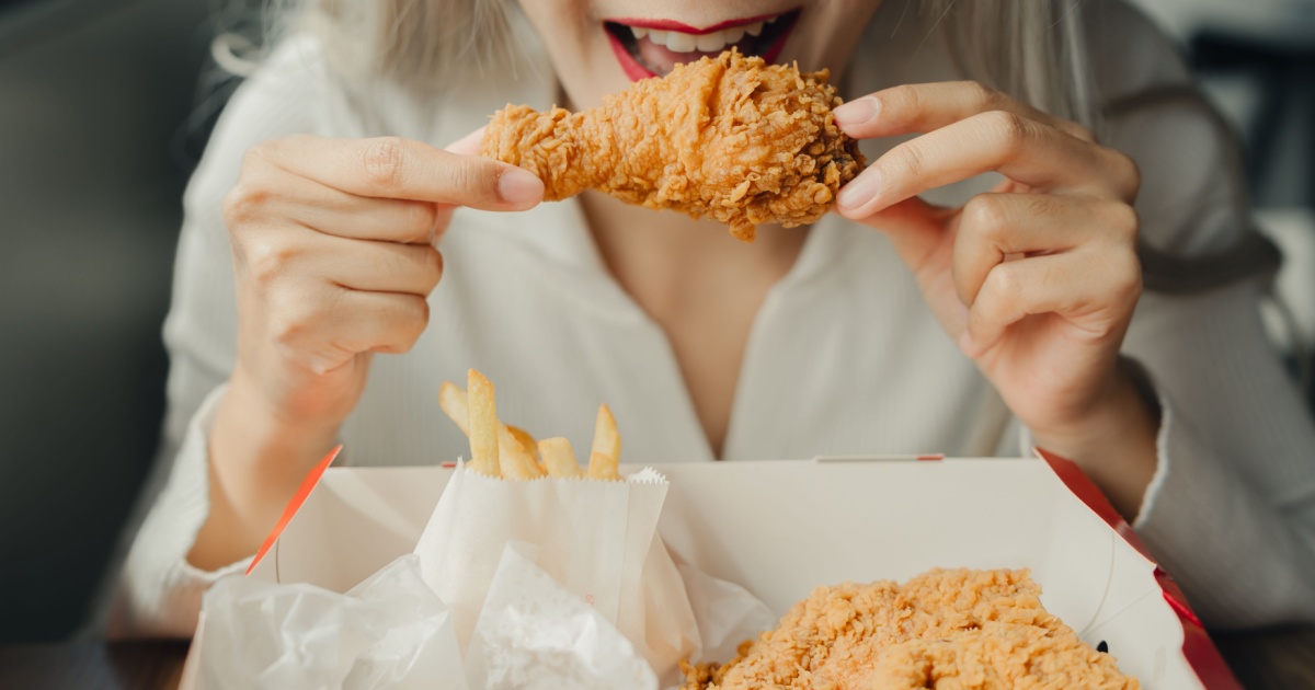 An Enjoying crispy fried chicken with fries in cozy setting
