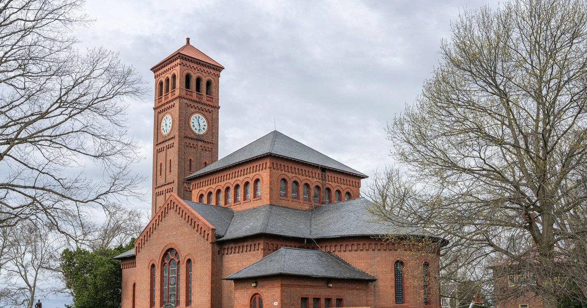 Red brick church with clock tower, surrounded by trees, in Hampton, Virginia.