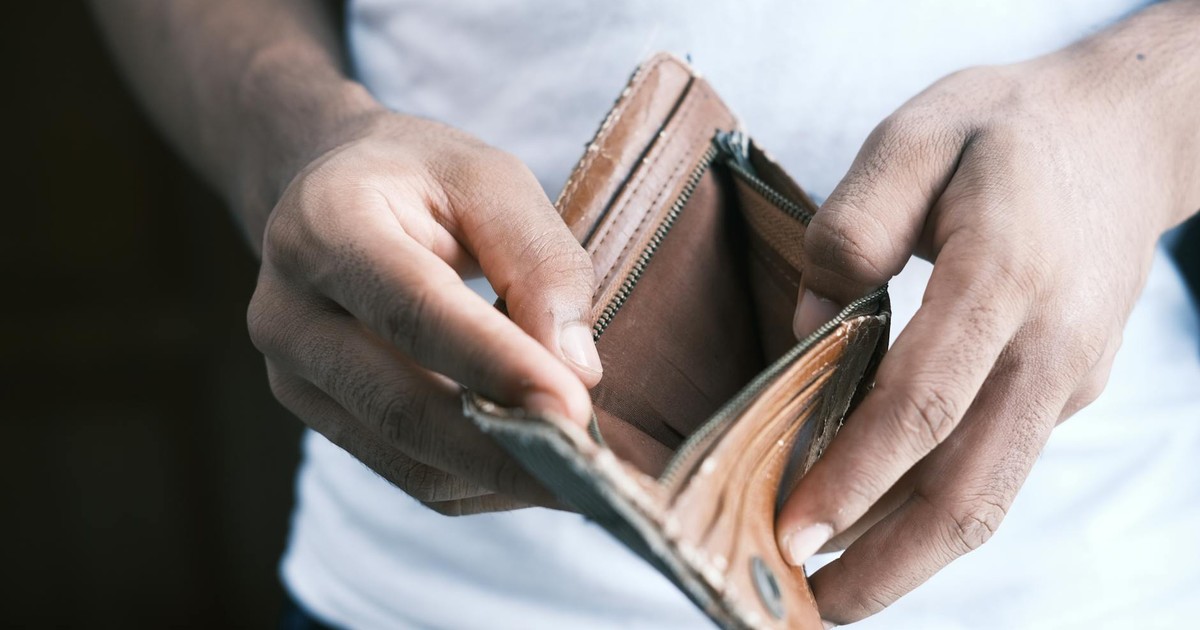 Close-up of hands holding an empty wallet, highlighting financial struggles and economic crisis.