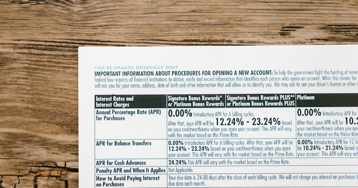 A detailed financial document listing interest rates on a textured wooden table.