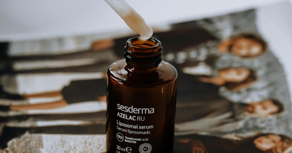A liposomal serum bottle with a dropper placed on a magazine with blurred background.