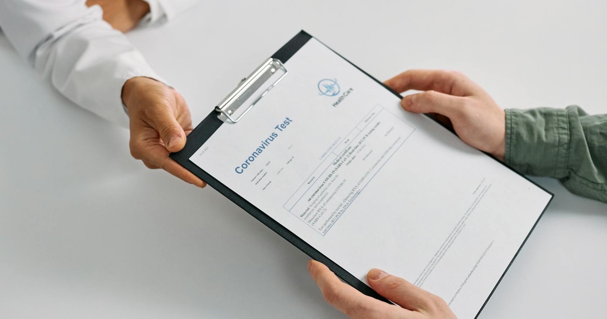A doctor hands over coronavirus test results to a patient during a consultation in a medical clinic.