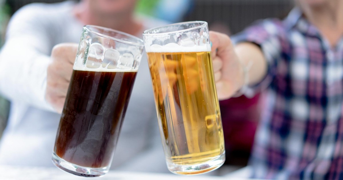 Two men toast with light and dark beer steins at Oktoberfest.