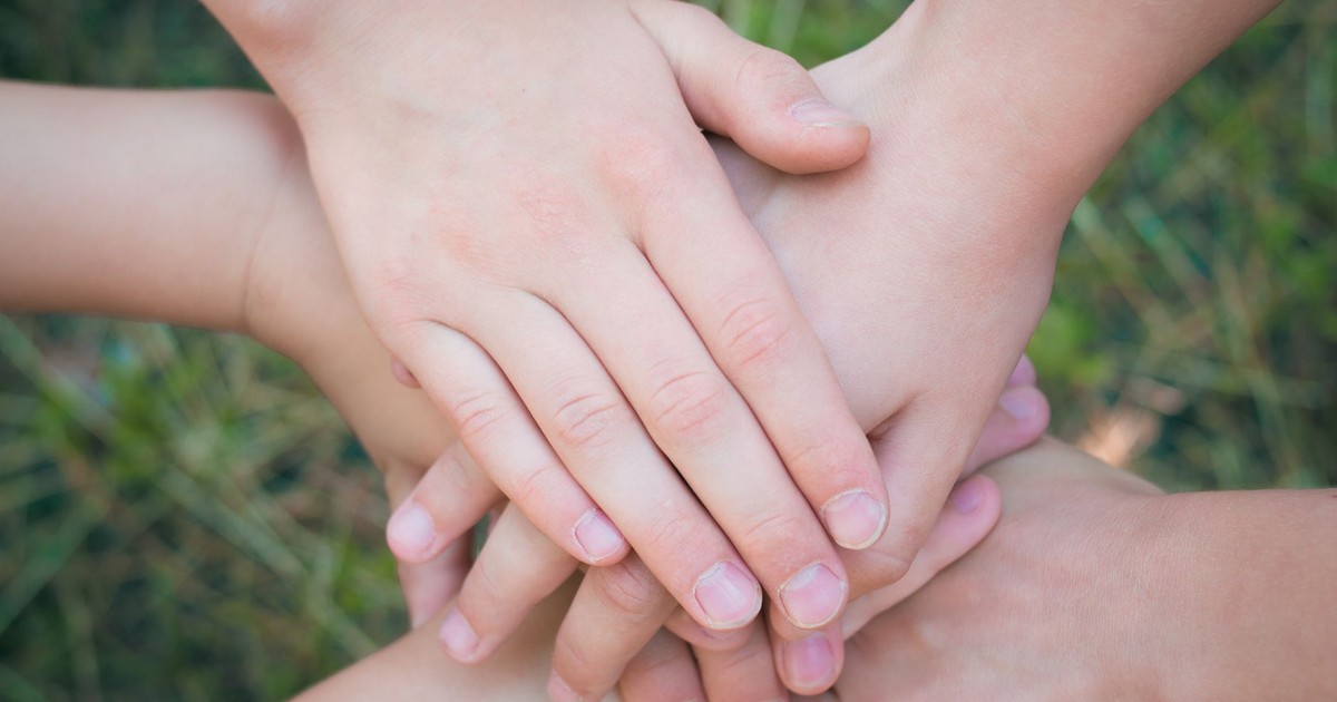 Close-up of diverse hands clasped together symbolizing unity and teamwork.