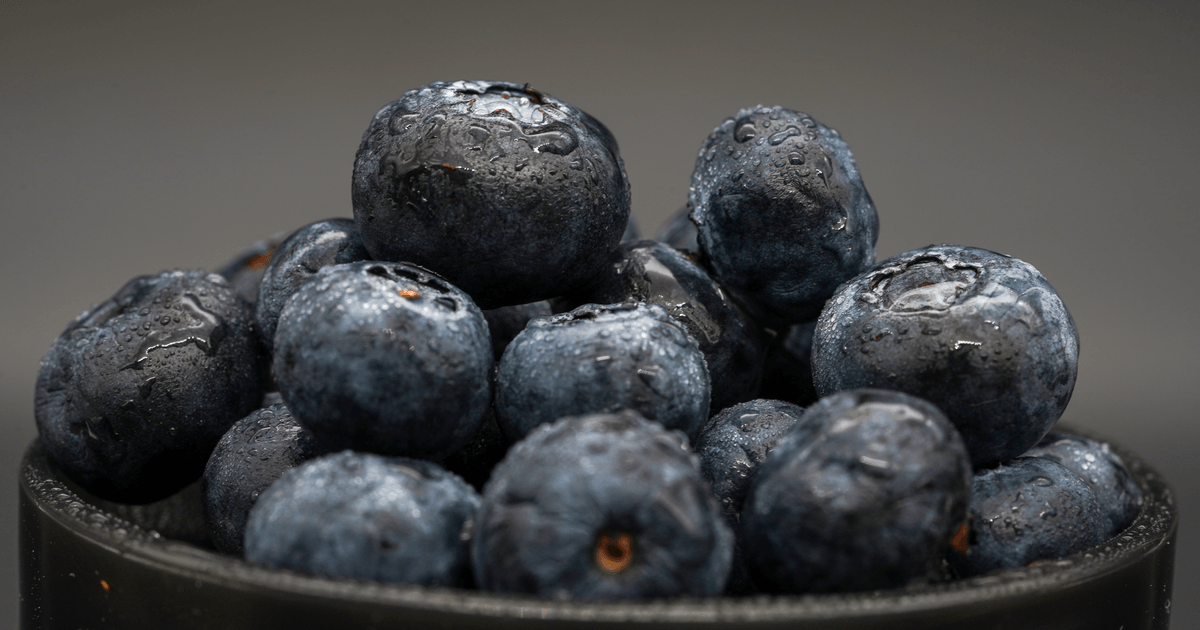 Close-up of fresh blueberries with droplets, highlighting the vibrant texture and freshness.