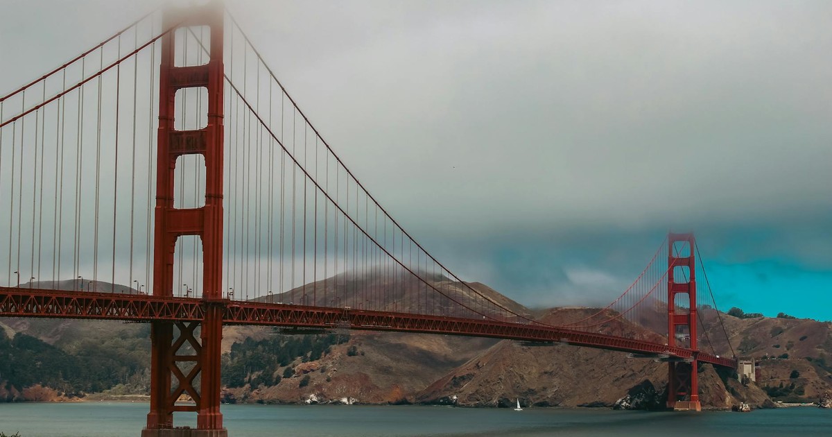 Iconic Golden Gate Bridge partially shrouded in mist over San Francisco Bay.