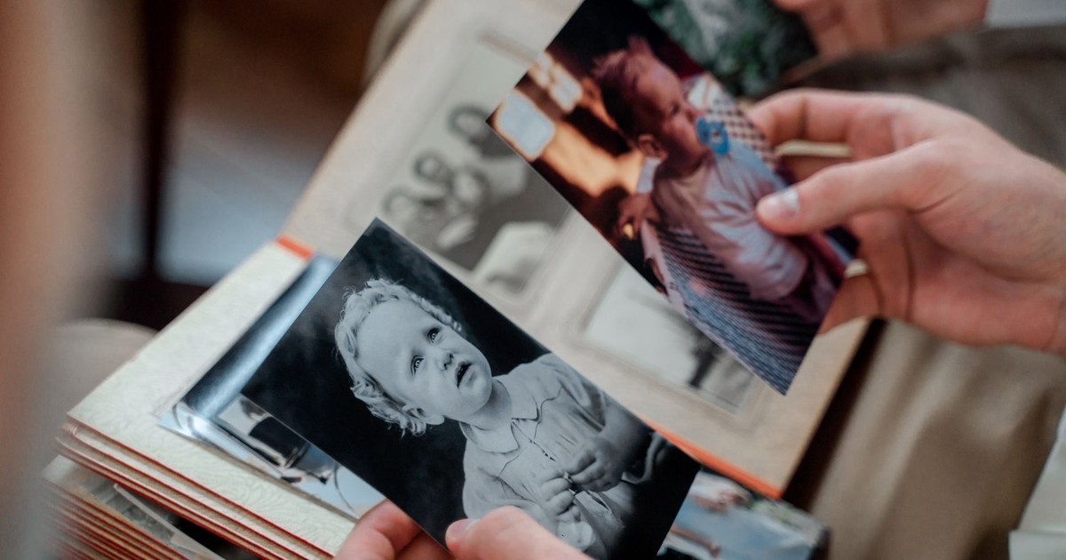 Close-up of hands examining nostalgic family photos in an album.