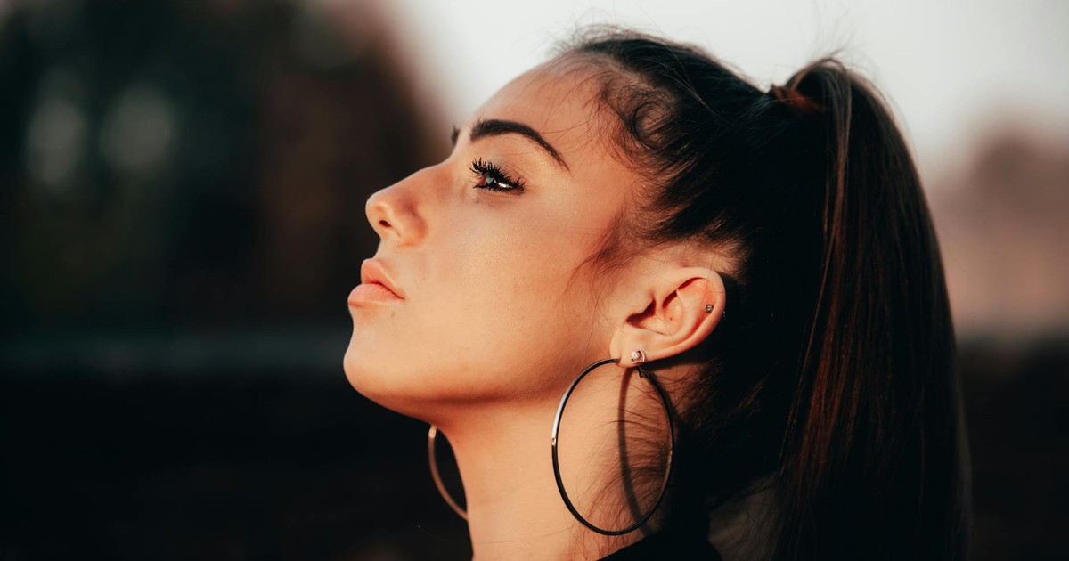 Elegant side profile of a young woman wearing hoop earrings outdoors in Mantova, Italy.