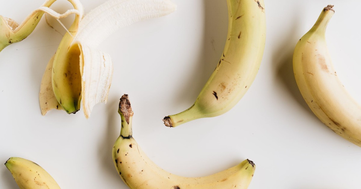 A flat lay photo of ripe bananas on a white background, showcasing healthy eating and minimalism.
