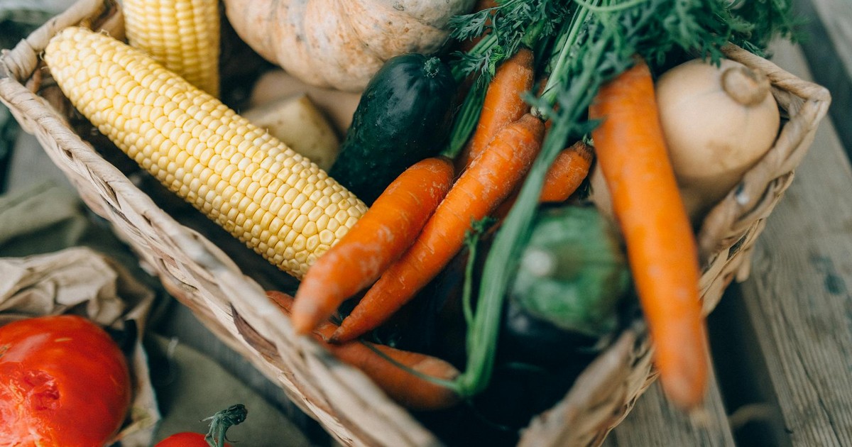 A close-up of fresh organic vegetables in a wicker basket, perfect for healthy eating.