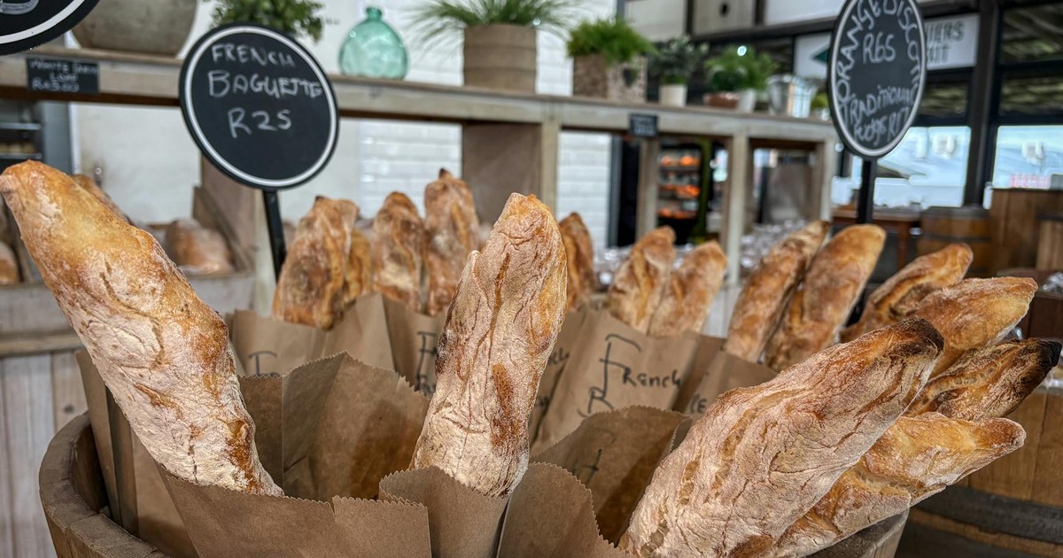 A display of freshly baked French baguettes in a rustic artisan bakery setting.