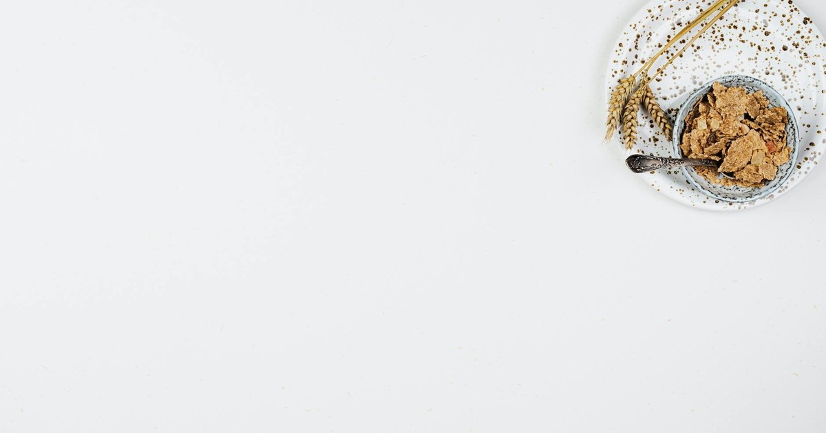 Minimalist style cereal bowl with wheat on a speckled plate, emphasizing breakfast simplicity.
