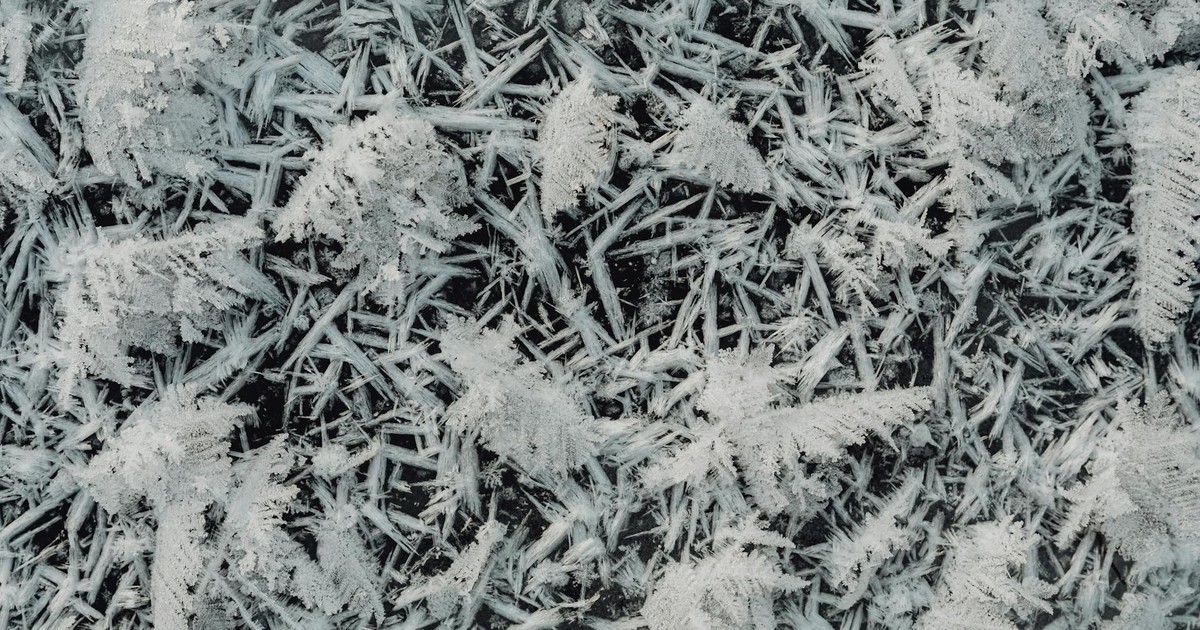 Detailed close-up of frost and ice formations on glass with a winter theme.