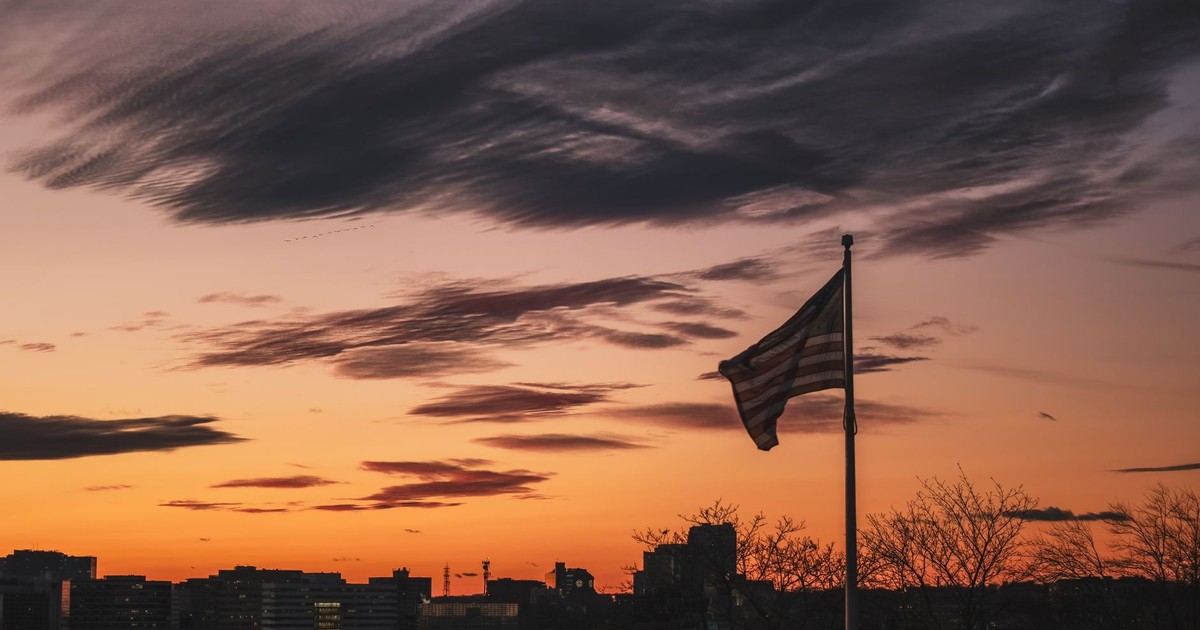 Beautiful sunset scene of American flag over Stamford skyline, Connecticut.