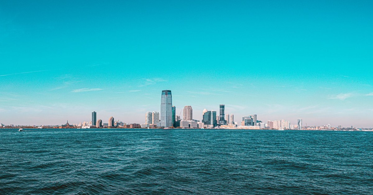 Panoramic view of Manhattan skyline with modern skyscrapers under a clear blue sky.