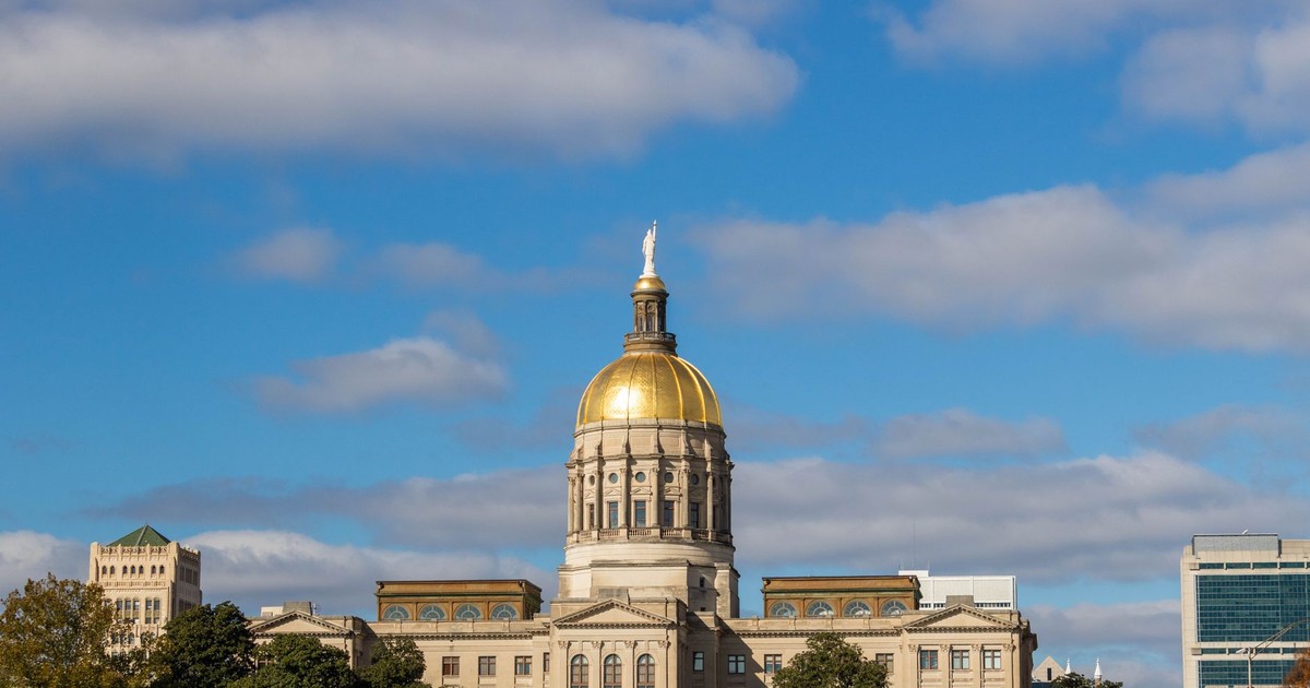 View of the Georgia State Capitol building with its iconic golden dome in Atlanta under a clear blue sky.