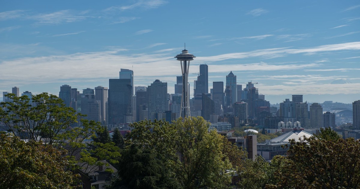 Panoramic view of Seattle with the iconic Space Needle under a clear blue sky.