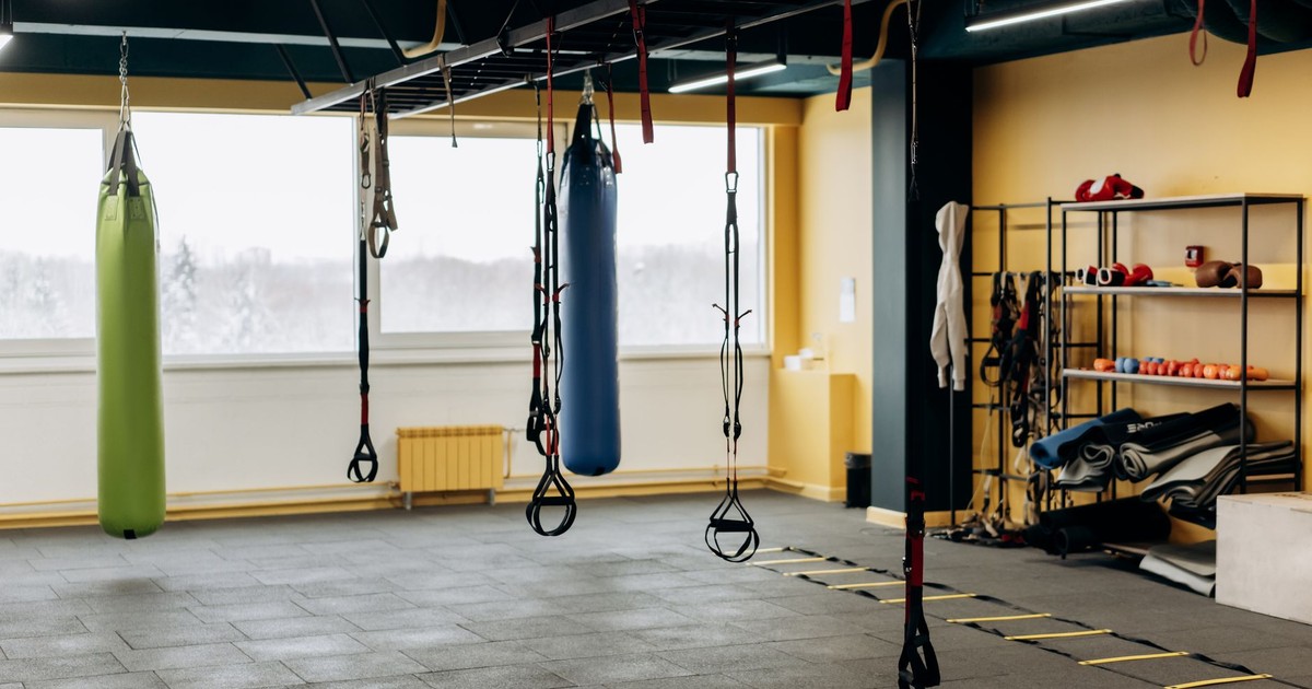 A modern gym with equipment, punching bags, and open space for workouts.
