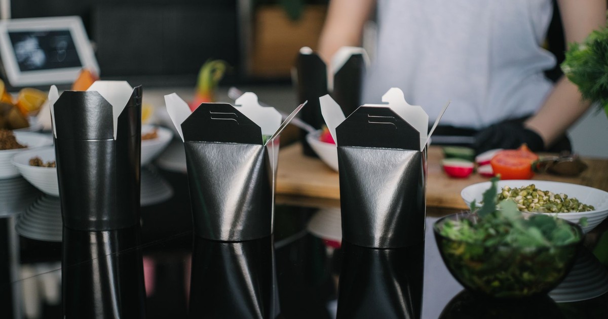 Stylish black takeout boxes on a contemporary kitchen counter, ready for takeaway.