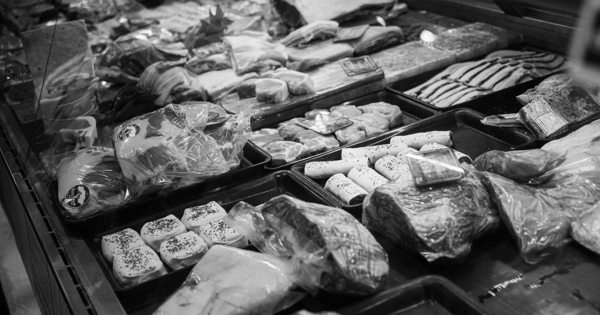 A monochrome butcher shop display featuring various packaged meats.