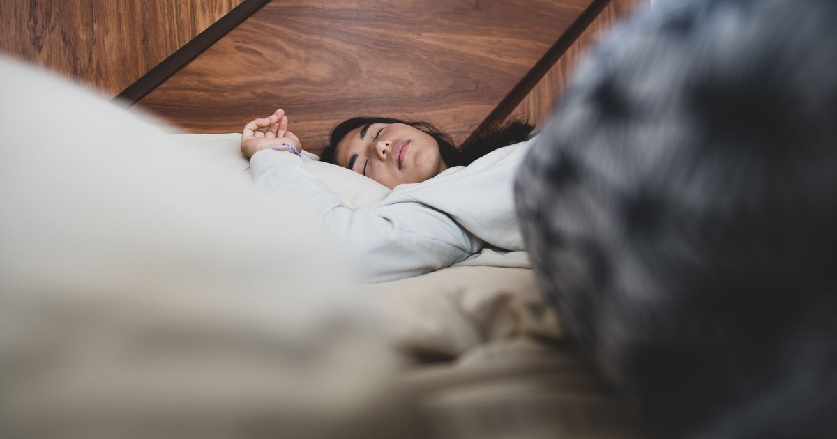 A woman peacefully sleeping on a bed, conveying relaxation and comfort.