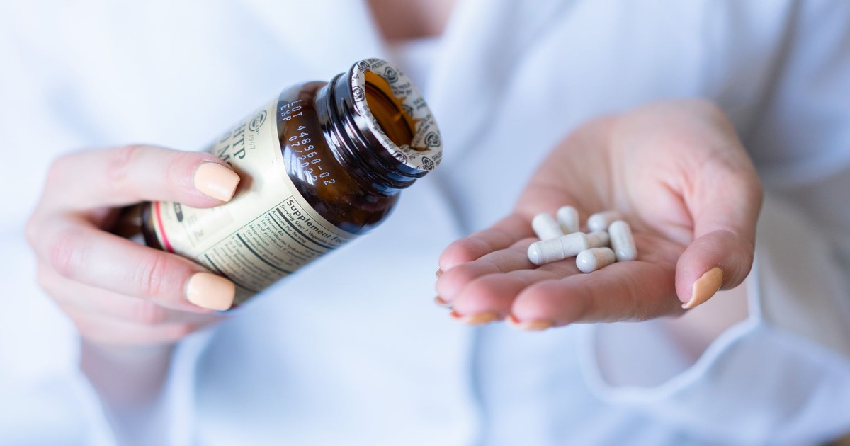 A close-up shot of hands holding a medicine bottle and pills, with a focus on healthcare and medication usage.