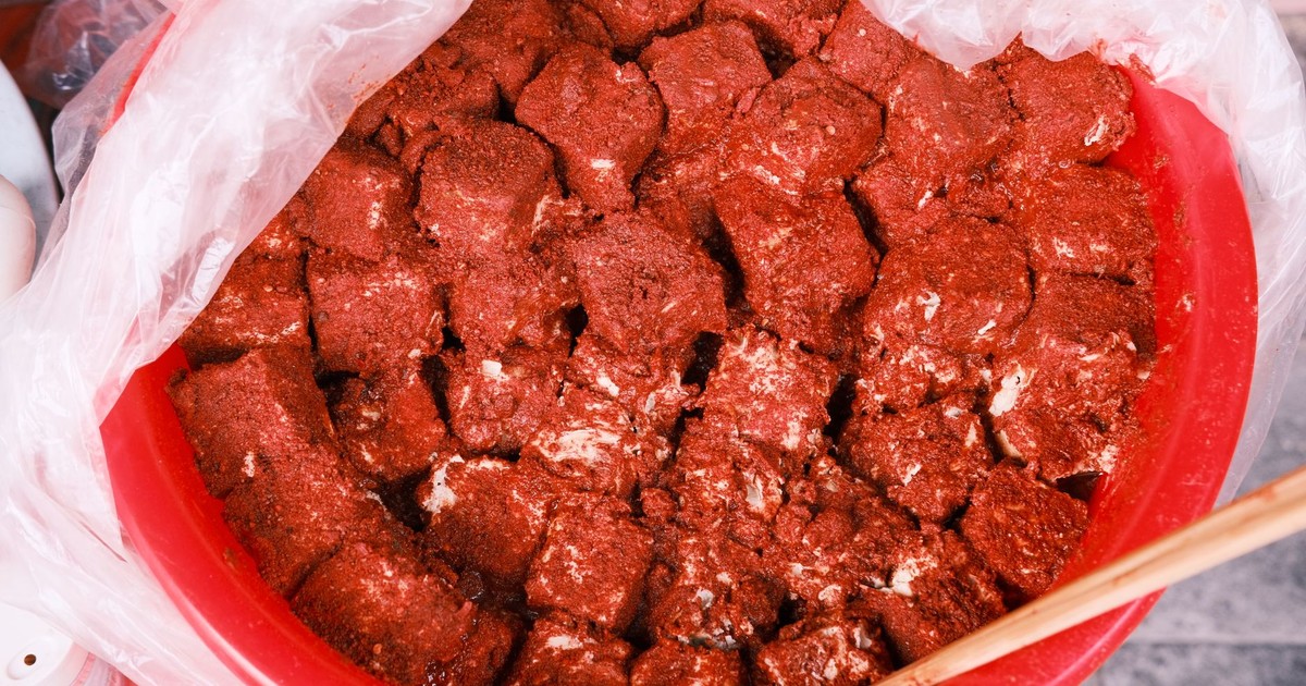 Freshly prepared spicy marinated tofu cubes in a red plastic bowl, ready to serve.