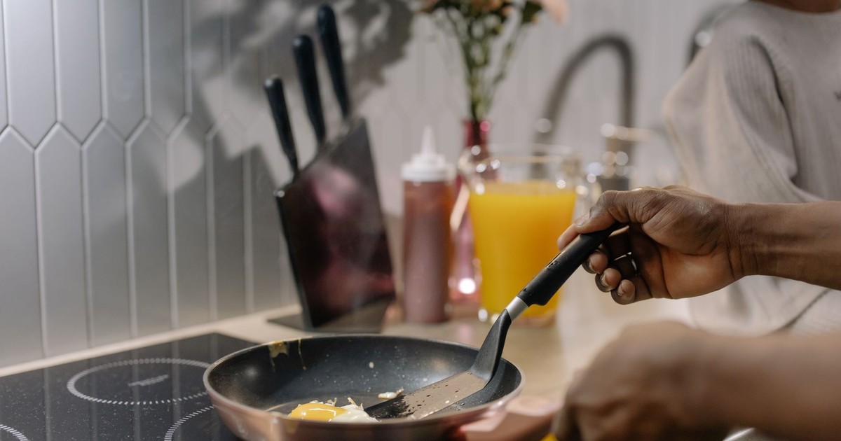 Close-up of frying eggs on an induction stove during morning breakfast preparation.