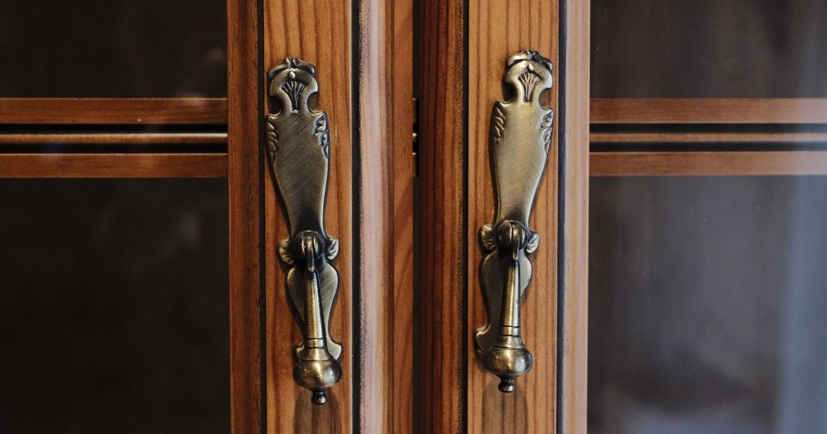 Close-up of elegant brass door handles on a wooden cabinet in Zaragoza, Spain.