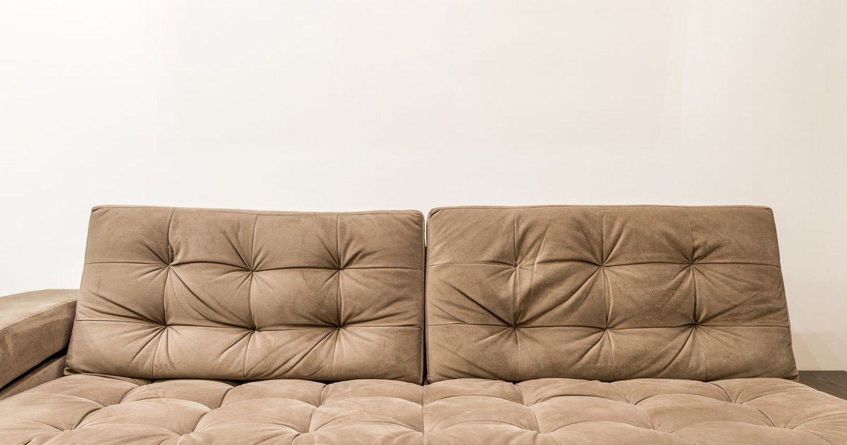 Comfortable brown couch with tufted design in contemporary living room setting.