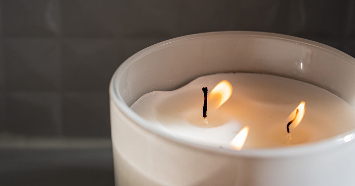 A close-up of a lit candle in a ceramic jar, creating a cozy atmosphere.