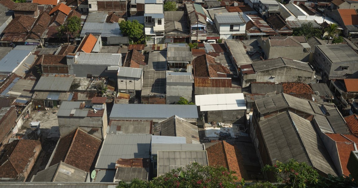 Aerial view highlighting dense urban rooftops in a tropical cityscape.