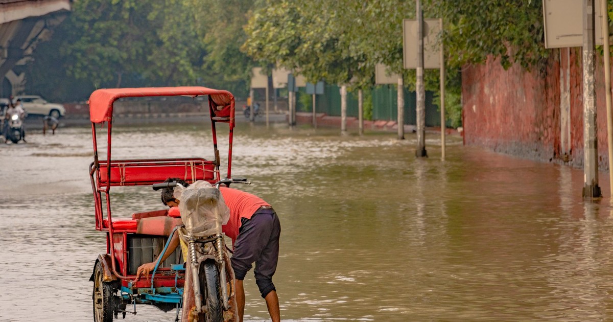 A rickshaw navigates a flooded street in New Delhi, India, during the 2023 monsoon.