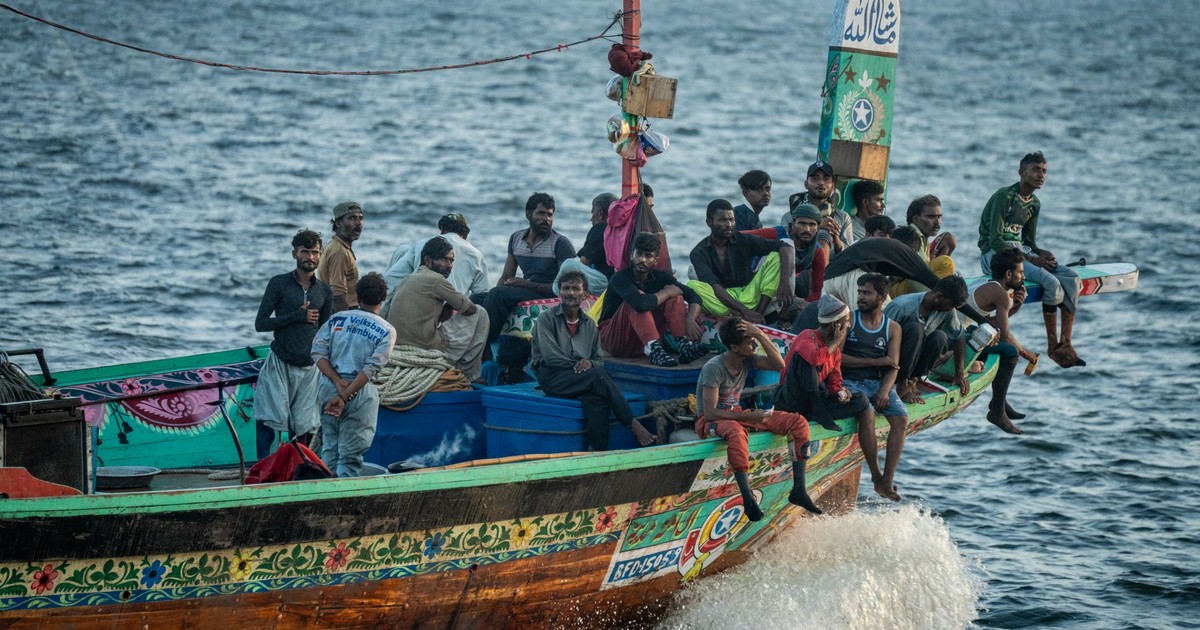 A colorful traditional fishing boat with a crew navigating the sea, showcasing cultural and marine life.