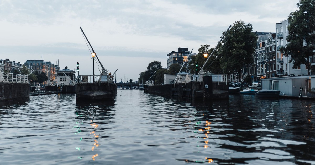 A serene evening view of Amsterdam's iconic canal with elegant waterfront buildings.