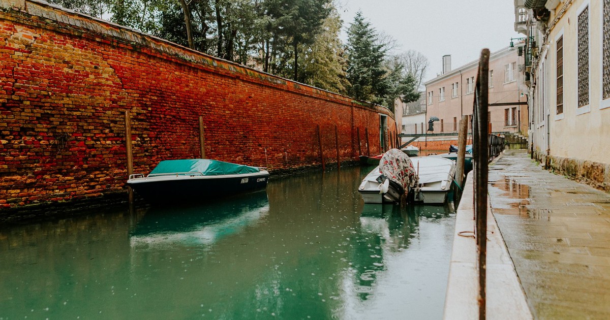 Tranquil view of a Venetian canal with boats moored alongside historic buildings.