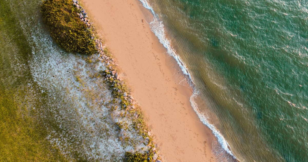 Beautiful aerial view of a sandy beach in Virginia with waves lapping at the shore.