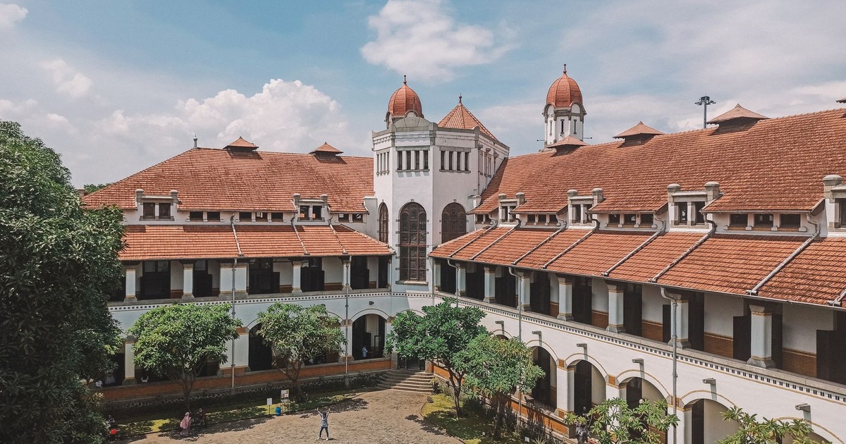 Captivating view of Lawang Sewu's courtyard with vibrant architecture and clear sky.