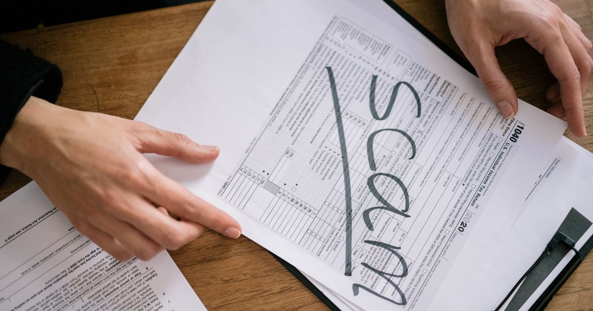 Documents highlighting tax fraud with the word 'scam' on tax forms.