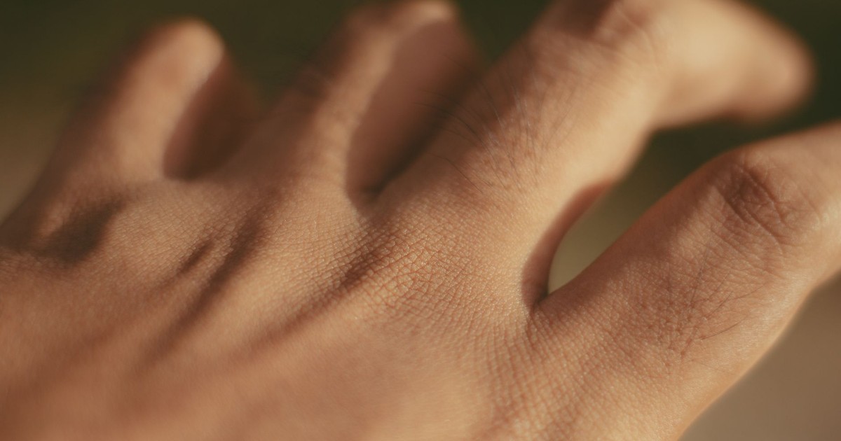 Macro shot of a human hand focusing on skin texture and pores in natural light.