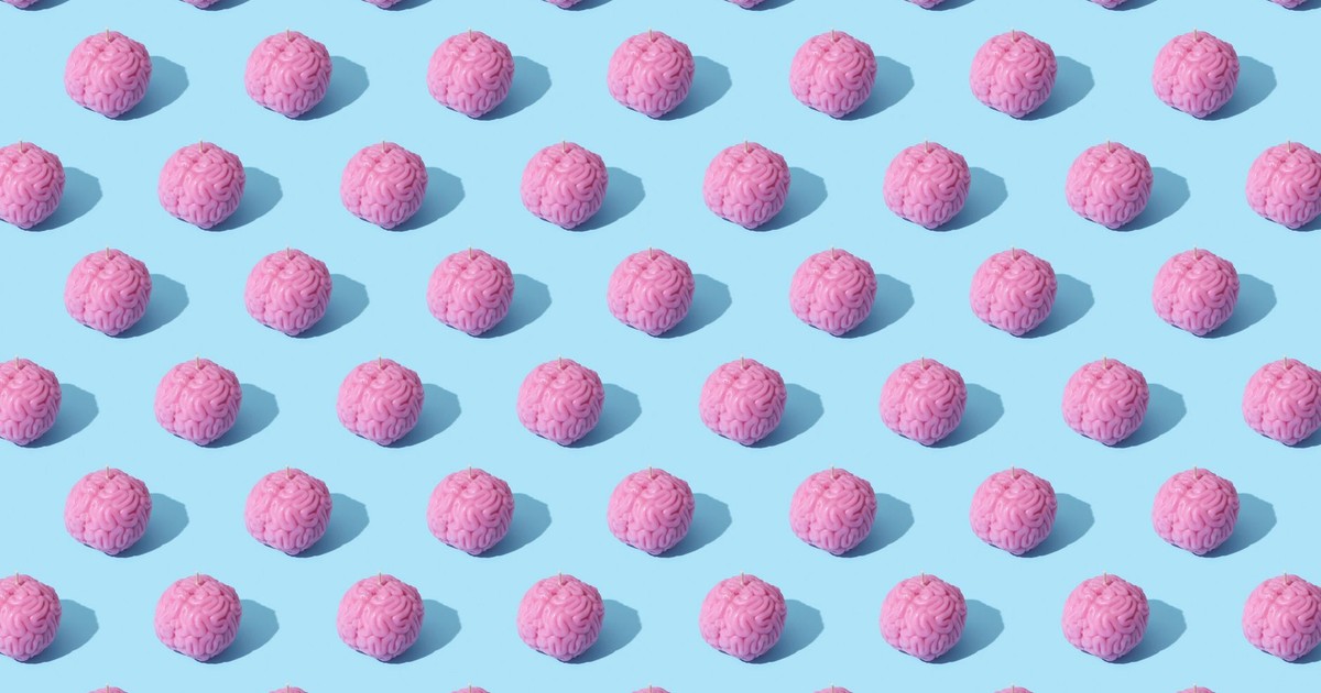 Creative composition of pink brain models in a repeating pattern on a light blue surface, showcasing abstract thinking.
