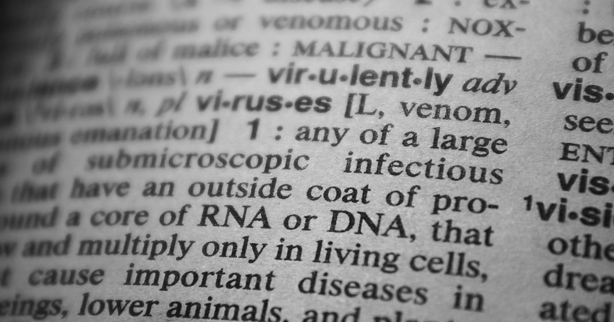 Black and white close-up of a dictionary page focusing on the definition of 'virus'.