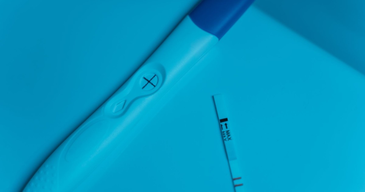Positive pregnancy test on blue surface, symbolizing new beginnings and family planning.