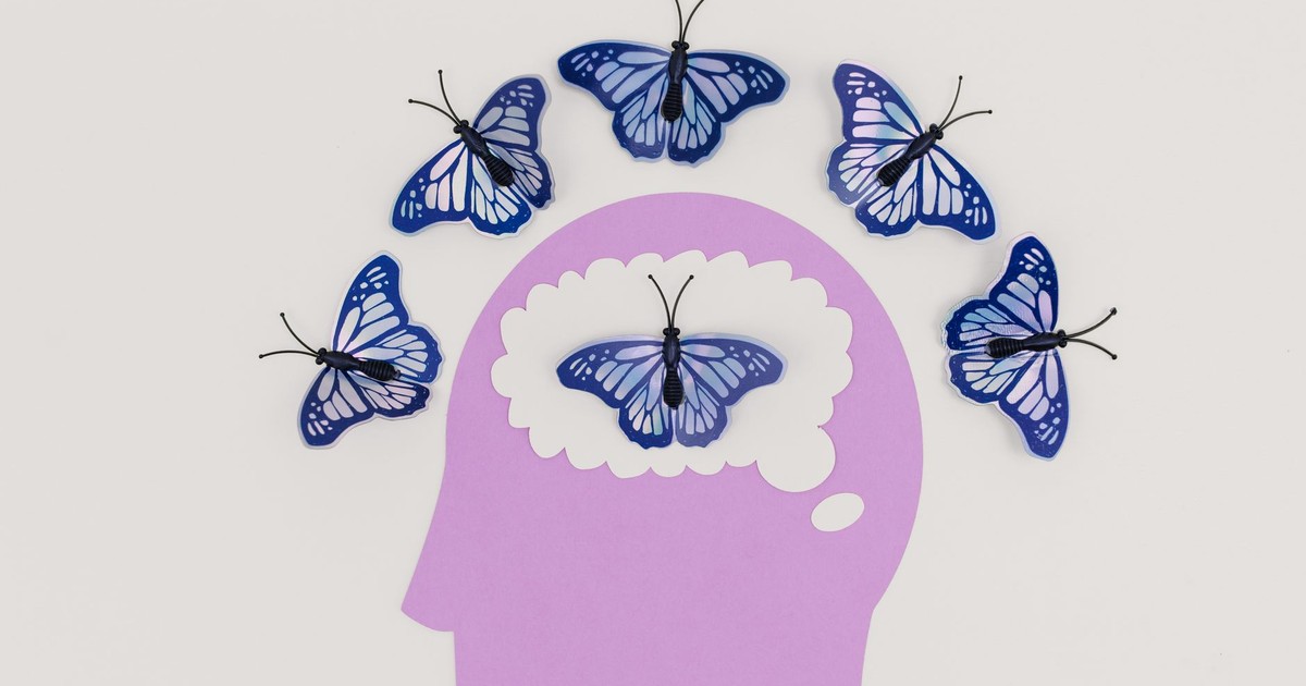 Creative illustration of butterflies representing thoughts over a brain silhouette.