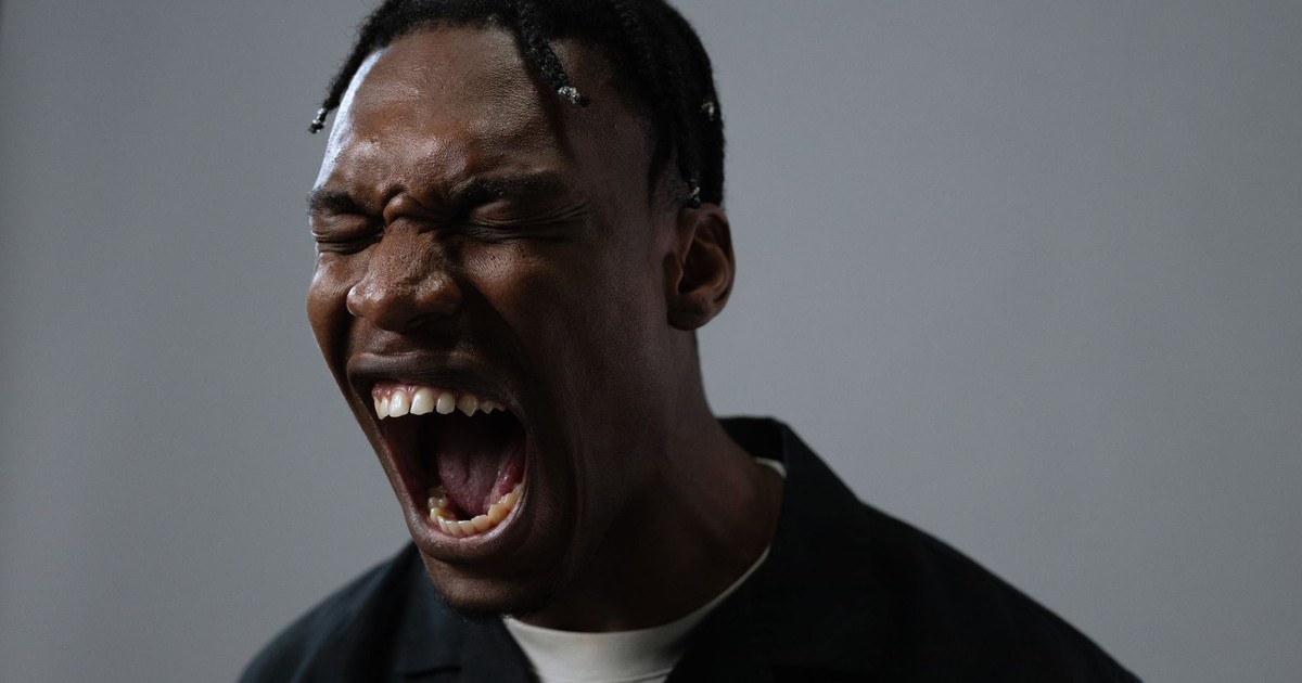 A powerful portrait capturing a man in a moment of intense emotion, possibly anger or frustration.