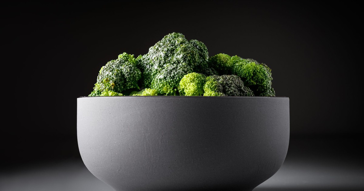 Close-up of fresh broccoli in a stylish black bowl against a dark background.